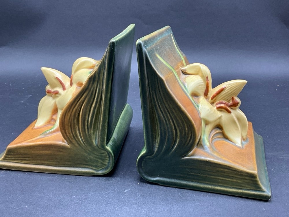 Roseville Pottery Bookends - Zephyr Lily: Roseville Pottery Bookends - Zephyr Lily.Marked 16 at base. Two paint flecks at edge of flower center. Please see photograph preview. Dimensions: 5 1/4” x 5 1/2” x 4 3/4”