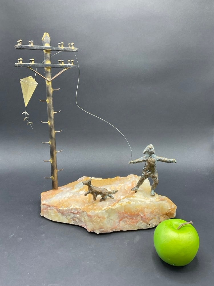 Curtis Jere (1910-2008) "Flying Kite" Bronze Sculpture: Curtis Jere (1910-2008) "Flying Kite" Bronze Sculpture. Girl with dog flying coat. Set on stone base. Dimensions 14.75” H x 12.5”W x 6.5”DPlease see photograph preview