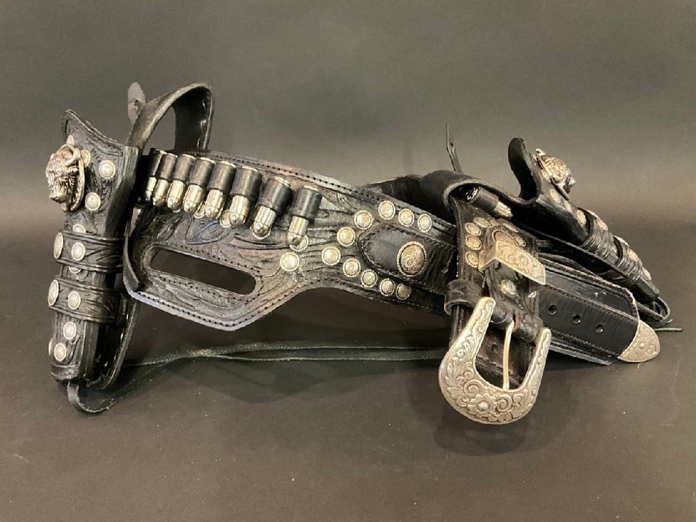 Vintage Black Leather Gun Holster Belt: Vintage Black Tooled Leather Gun Holster Belt. Purchased in Texas from Mexican artist. Artist unknown. Used for Buffalo Bill Show. Dimensions: 53” x 3” w/ gun holster - 53” x 10&rdqu