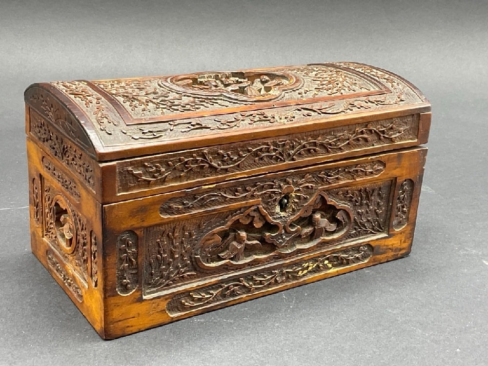 Antique Chinese Carved Wood Chest: A Chinese carved wood jewelry box or chest. 19th century. Very ornate design with purple pillow lining. Dimensions: 4 1/2” x. 8 1/4” x 4”