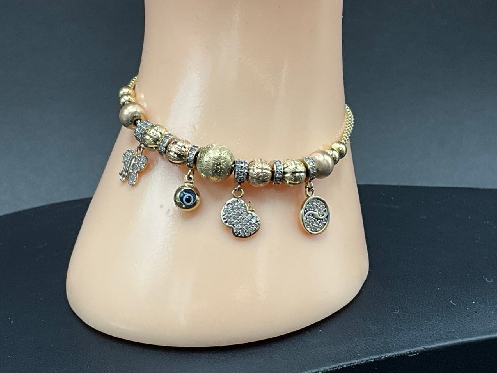 14K (585) Contemporary Charm Bracelet w/ Evil Eye, Diamonds: 14K (585) Yellow, white and rose gold charm bracelet with diamond encrusted balls, hearts and glass evil eye charm. One charm has three (3) diamonds missing. Please see photograph preview. Worth repai