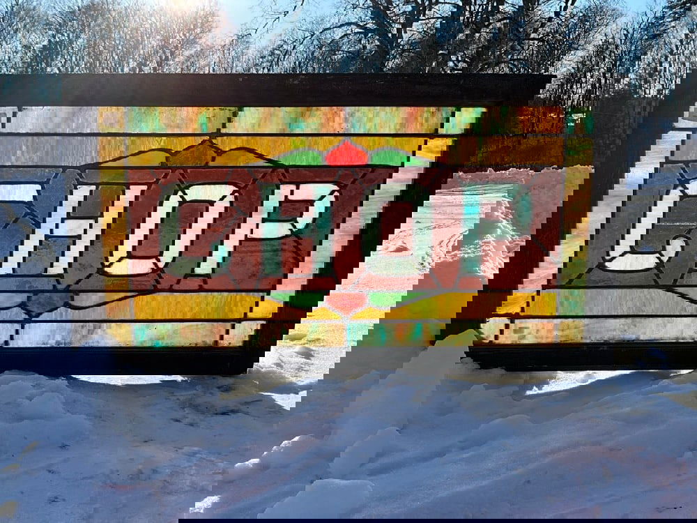 Stained Glass Framed Window “CHOP: Stained Glass Transom Window “CHOP” Housed in a hardwood frame.Condition - Paint chipping on frame. Dimensions:19 1/2” x 35 1/2” x1 1/2” Inv. 170