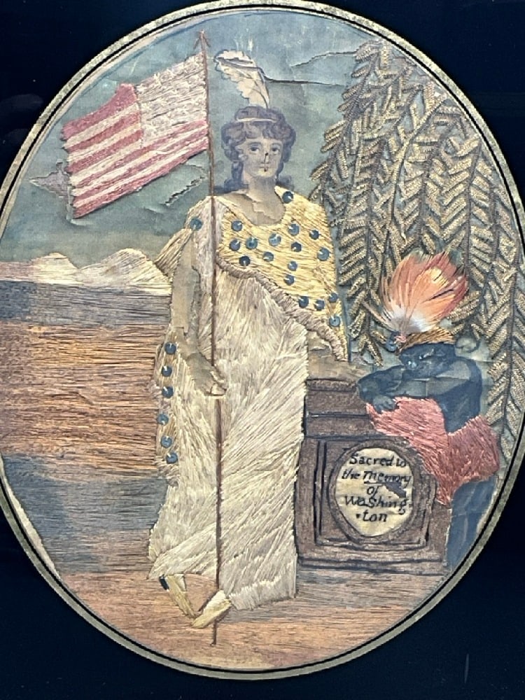 C.1800 Silk Embroidery Sampler In Memory of George Washington: An early American silk embroidery in memory of George Washington. A patriotic piece with lady liberty holding a fifteen star flag. A blackamoor figure stands next to a small monument that reads : "Sac