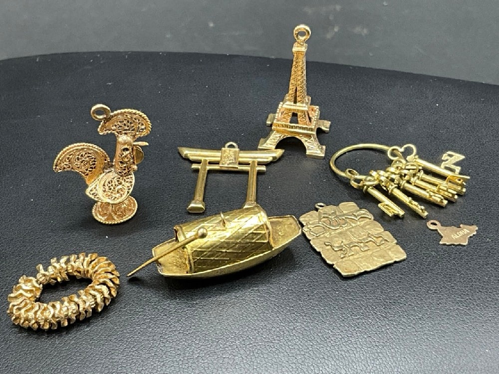 Eight (8) 14K Yellow Gold Charms. Bracelet charms including ring, Eiffel tower, Rooster, Chinese: Eight (8) 14K Yellow Gold Charms. Bracelet charms including ring, Eiffel tower, Rooster, Chinese etc. As seen in photograph preview. Total weight: 21.1 grams.