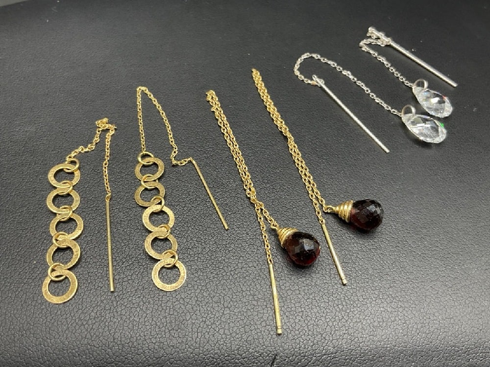 Three (3) 14K Yellow Gold Threading Dangle Earrings: Garnet, 4 1/4” drop, White gold 3 1/2” hoops 4”Total weight: 5.3 grams.