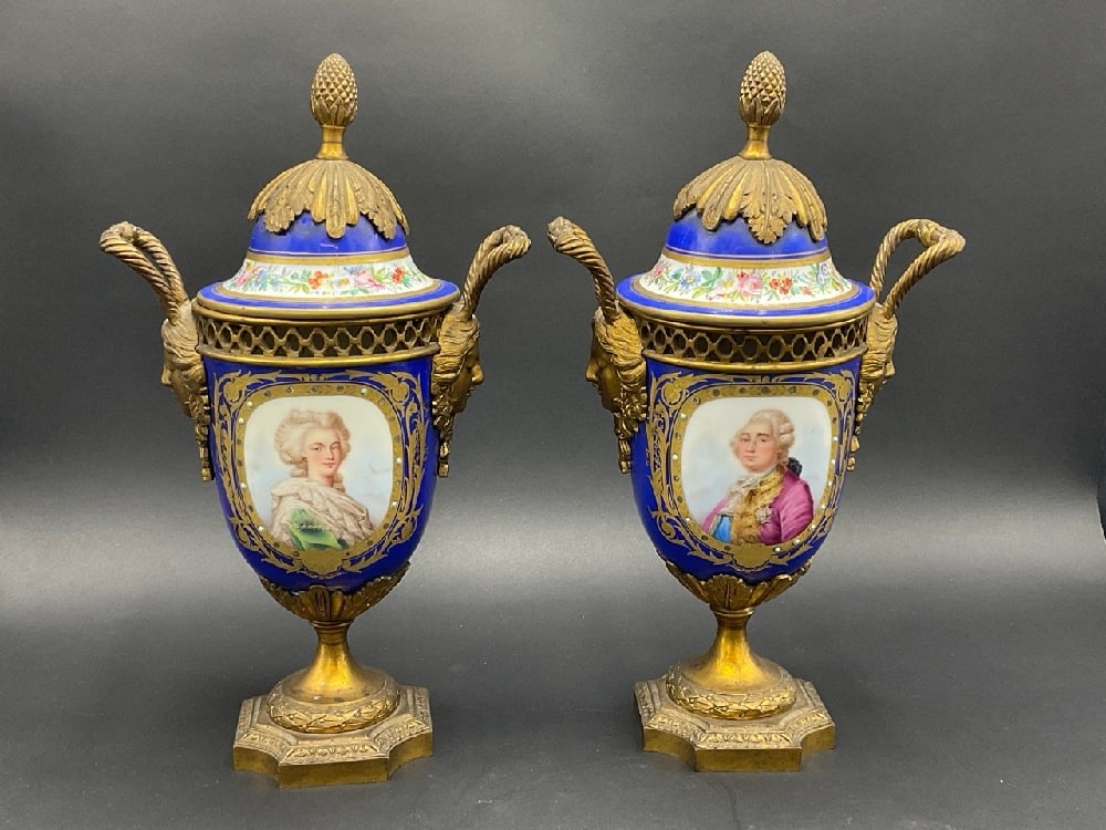 A Pair, Sevres French Bronze Ormulu Mounted Mantle Vases: A Pair, Sevres French Porcelain and Bronze Ormulu Mounted Mantle Vases. Condition: One vases has interior crack. Please see photograph preview. Dimensions: 12 1/2” H w/ Lid x 7” Handle to