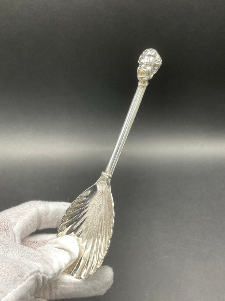 A Sterling Silver Serving Spoon with Scalloped Edge Bowl and Blackamoor Figural Head: A Sterling Silver Serving Spoon with Scalloped Edge Bowl and Blackamoor Figural Head. Late 19th Century or Early 20th Century. Marked Sterling, Handmade with maker's mark "M" Dimensions: 6