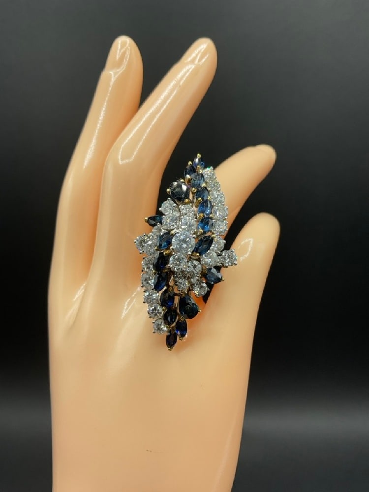 18K White Gold Diamond and Blue Sapphire Cocktail Ring: Lady's 18KT White And Yellow Gold Cocktail Ring.One lady’s handcrafted ring, size 6, fashioned in 18 karat white and yellow gold, weighing 14.6 grams. The ring isdesigned in a dimensional floral