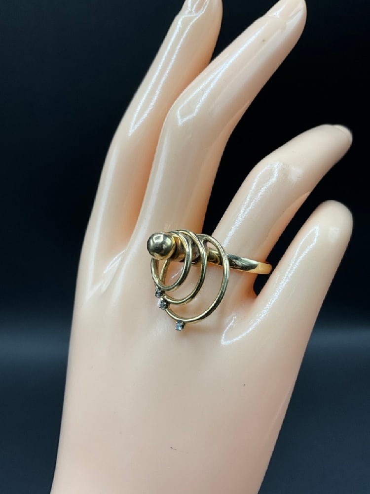 1975 Norman Teufel 14K Yellow Gold Kinetic Spinner Diamond Ring: 1975 Norman Teufel 14K Yellow Gold Kinetic Spinner Diamond Ring. Having three (3) mounted concentric diamond studded circles. Size 7Total weight: 6.75 grams.Condition Note: Bottom circular ring is loo