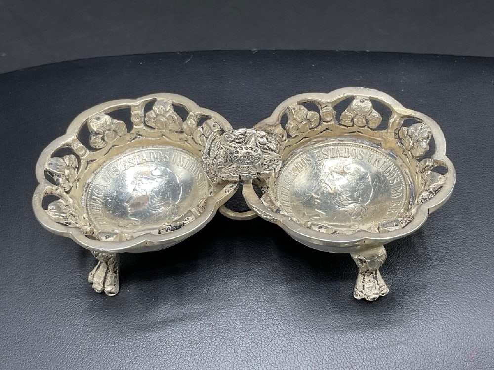 Coin Silver Dish Two (2) 1907 Brazilian Coins 2000 Reis: A Brazilian Coin Silver Footed Ashtray. Two (2) 1907 Brazilian 2000 Reis Coins. Total weight: 96 grams . Dimensions: 3 1/2” x 1 3/4” .