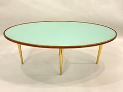 Jonathan Adler Oval Coffee Table: Jonathan Adler Oval Coffee Table. Aqua blue glass type with brass legs. Dimensions: 16" X 42" X 22"