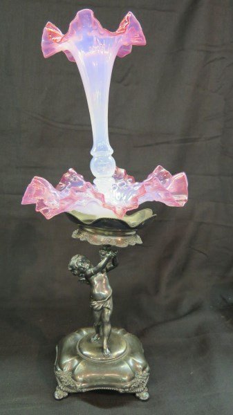 Figural Glass Victorian Epergne: A Figural pink glass ruffled epergne set upon a Victorian silverplated base. Possible marriage. Uneven setting. Dimensions:22"h