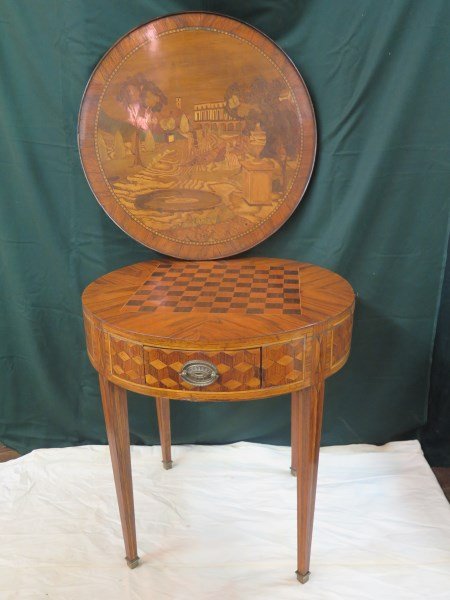 A fine Louis XVI style marquetry games table: A fine Louis XVI style marquetry and parquetry inlaid kingwood and tulipwood cross-banded gueridon, 19th century, the circular galleried top centering a scene after the antique with figures and buildi