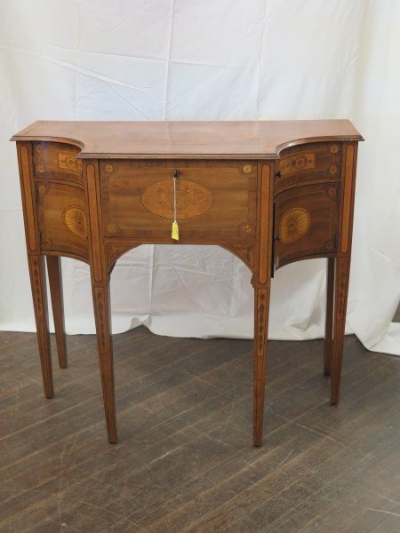 Sheraton Style Mahogany Veneered Satinwood Inlaid: A fine Sheraton style mahogany veneered satinwood inlaid cellaret, the shped molded top with inlaid Neoclassical urn form motif above a central inlaid drawer flanked at either side by Two (2) concave 