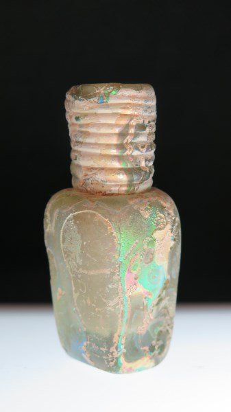 Ancient Roman Glass Ribbed Scent Bottle: An Ancient Roman glass ribbed scent bottle. Dimensions: 2 3/4" X 1". Green iridescent coloring.