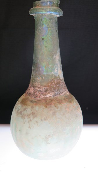Ancient Roman Glass Bulbous Bottle: An Ancient Roman glass bulbous bottle, green iridescent color. Dimensions: 7" height X 3" width.