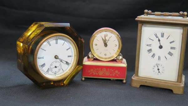 Estate Dresser Clocks Group: Three estate dresser clocks including 19th Century carriage clock, all complete, one side glass broken. Reuge clock and E.N. Welch signed Amber glass clock. Inv. 143, 148, 69
