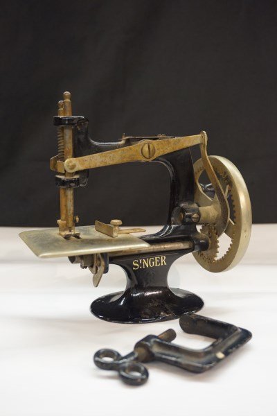 Singer Child Sewing Machine: A Child's Singer sewing machine. Includes original clamp as seen. Dimensions: 7" X 7" X 4"