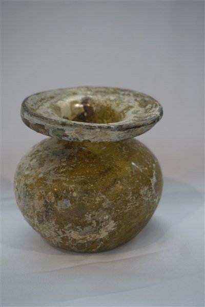 Ancient Roman Glass Marigold Bottle: An ancient Roman glass marigold color bottle. Dimensions: 3"h X 3"w Provenance: Collection of the late Mr. Hugh D. Farley. Mr. Farley acquired the pieces while he was the Director of the US Foreign Ai
