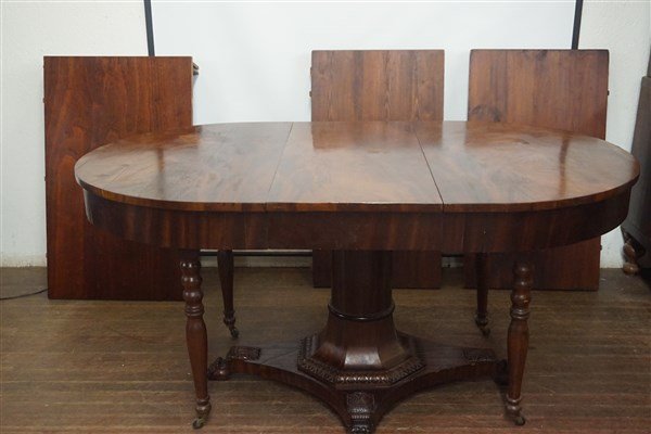 Regency Mahogany Dining Room Table: A Regency mahogany flame grain mahogany dining room table. Carved pedestal base. 19th century label stating property of US Consulate, Washington D.C. with inventory number. Dimensions: 30" X 47" X 39"
