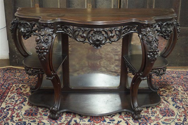 American Carved Rosewood Etagere Table: An American carved rosewood etagere table with mirrored back. Highly ornate carved florals. Dimensions: 64" X 31" X 22" Inv. 6