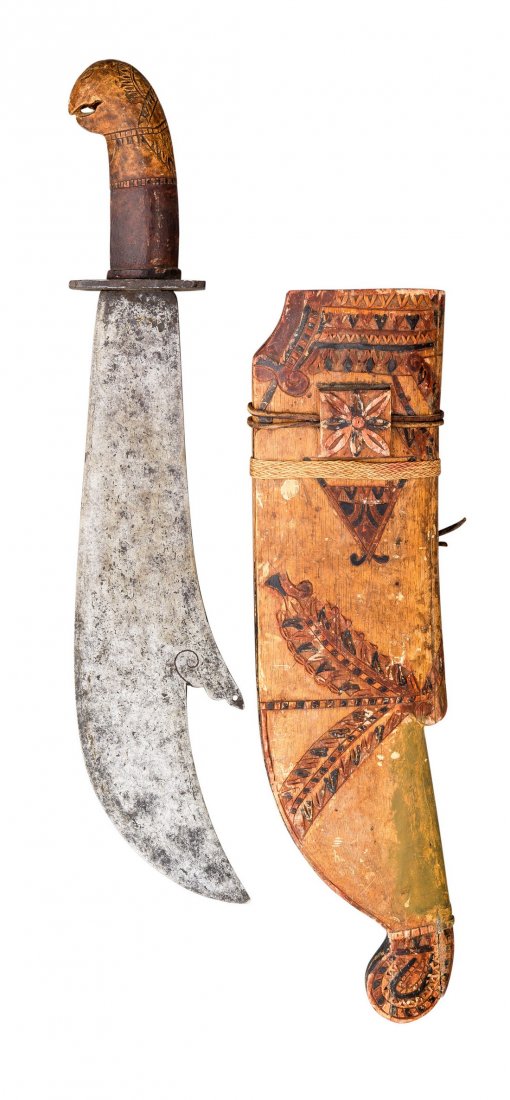 A SOUTH EAST ASIAN MACHETE, 19TH CENTURY, PROBABLY: A SOUTH EAST ASIAN MACHETE, 19TH CENTURY, PROBABLY CEYLON with broad blade formed with a clipped-back point, rectangular iron guard, carved hardwood grip, in its carved wooden scabbard bound with ratt