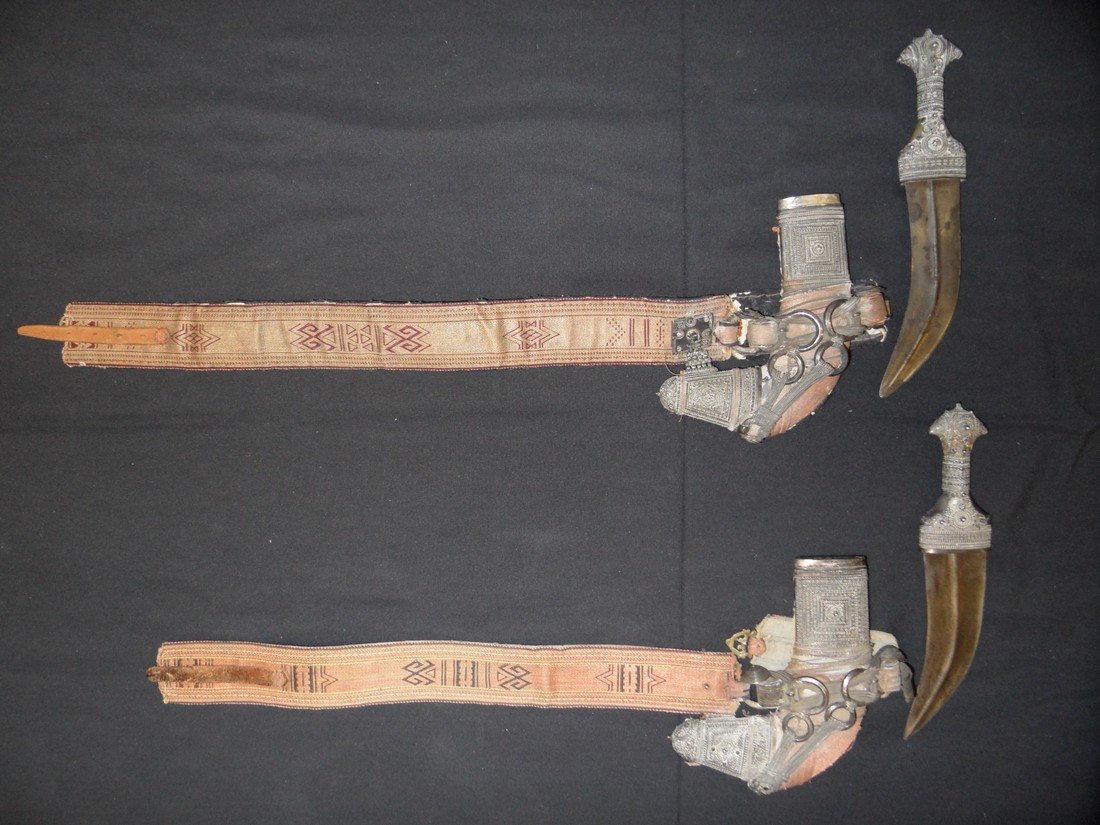 TWO ARAB SILVER-MOUNTED DAGGERS (JAMBIYA), 19TH CENTURY: TWO ARAB SILVER-MOUNTED DAGGERS (JAMBIYA), 19TH CENTURY each with curved double-edged blade formed with a medial ridge, characteristic hilt decorated with beadwork, in its wooden scabbard applied with