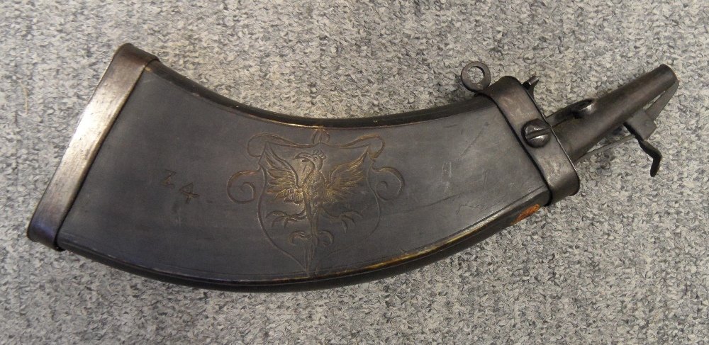 A GERMAN ENGRAVED COWHORN POWDER-FLASK, EARLY 17TH: A GERMAN ENGRAVED COWHORN POWDER-FLASK, EARLY 17TH CENTURY with dark stained curved flattened body numbered '24', the inner face plain, the outer surface decorated with a a heraldic shield charged wit