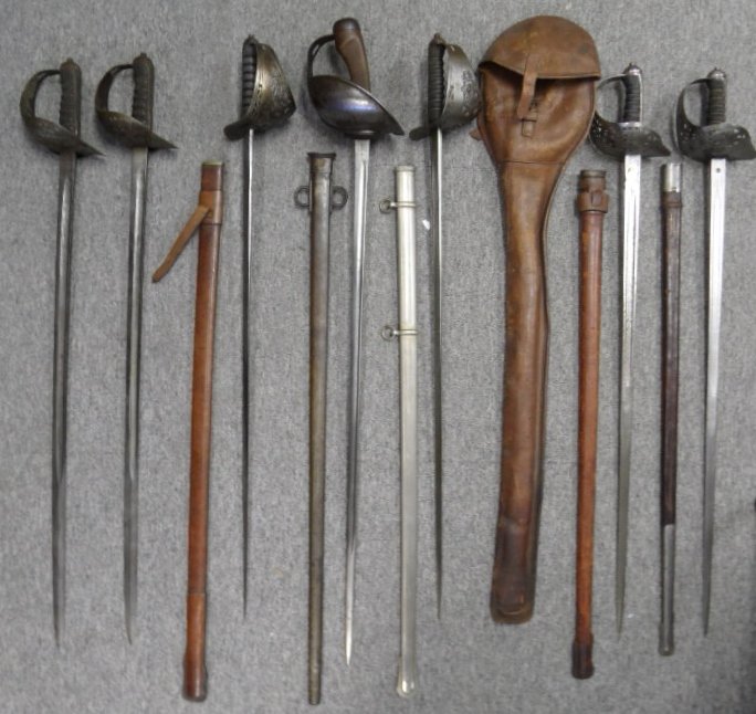 A 1908 PATTERN CAVALRY SWORD AND SIX 1897 PATTERN: A 1908 PATTERN CAVALRY SWORD AND SIX 1897 PATTERN INFANTRY SWORDS the first dated '11, in its scabbard; the second by Wilkinson, no. 37555 for 1900, with etched blade including crowned Royal cypher an
