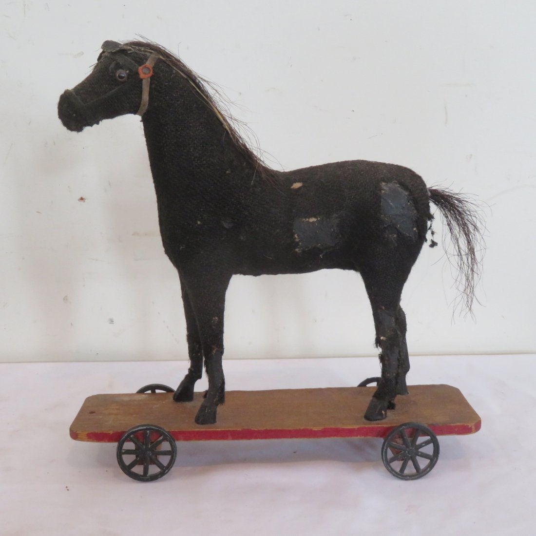 Burlap covered toy horse on wheels: Black burlap covered toy horse on wheels, wood platform, metal spoked wheels, 14.5" x 12" x 3.5"