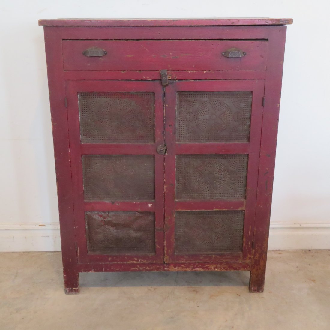 Red painted tin door pie safe: Red painted tin door pie safe, poplar, star tins, dove tail drawer, square nail construction, 52" x 39.5" w. x 17"