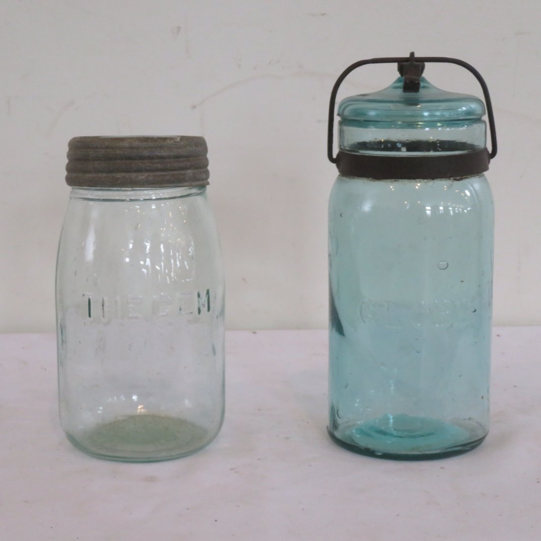 2 aqua canning jars, 1 Globe and 1 The Gem: 2 aqua canning jars, The Gem jar has a patent date of Nov. 20, 1867 on bottom, has the number 232 on bottom, lid is zinc and glass, 7"H x 3.75"W. Globe jar lid is dated May 25, 1886, 8.5"H x 3.75"W.