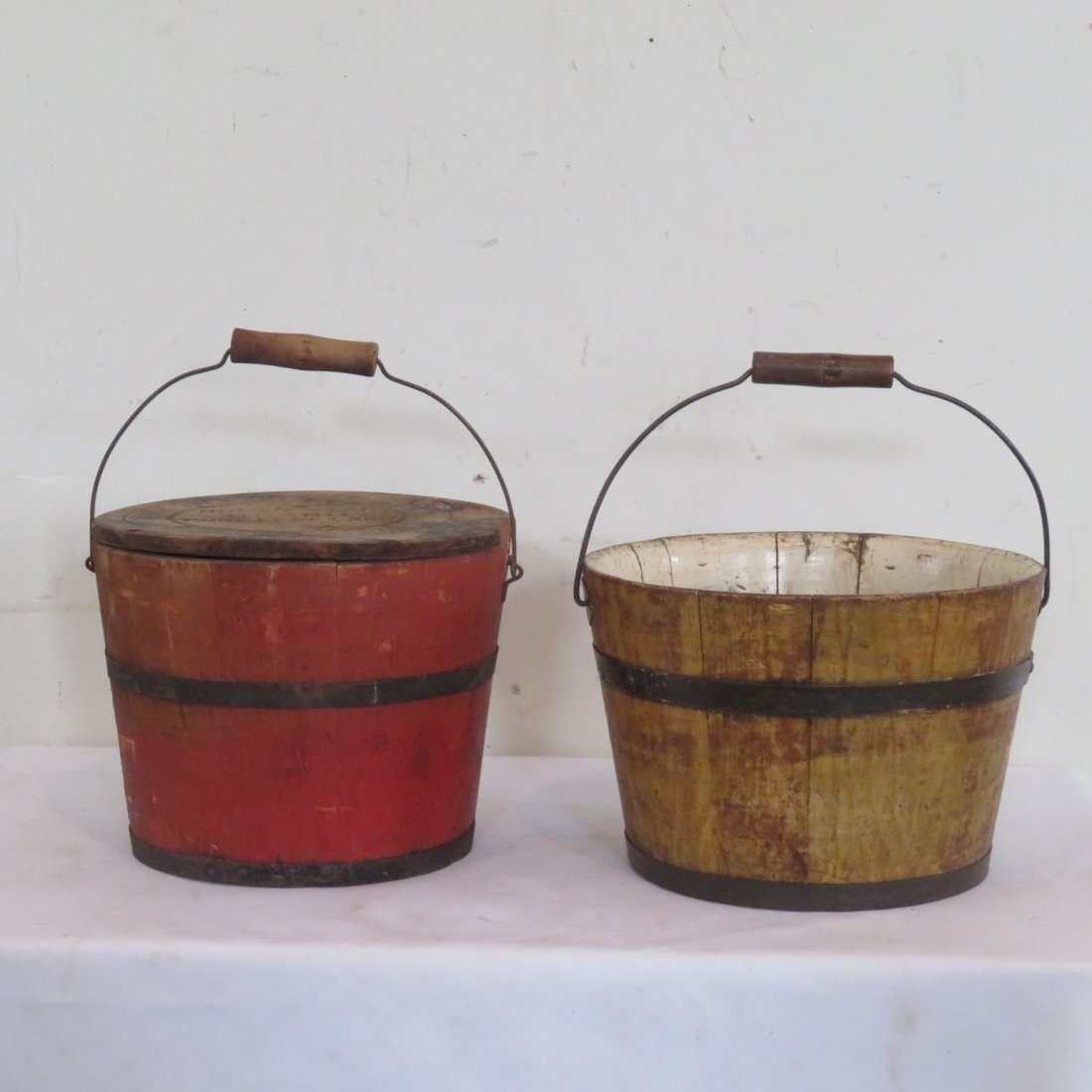 2 wooden pails, one with signed lid: 2 wooden pails, one is mustard with with wire bale and wood handle 7"H x 10"W, one is old red paint with lid signed North Star Brand Pure Leaf Lard, Boston, USA with wire bale and wood handle 8"H x 10