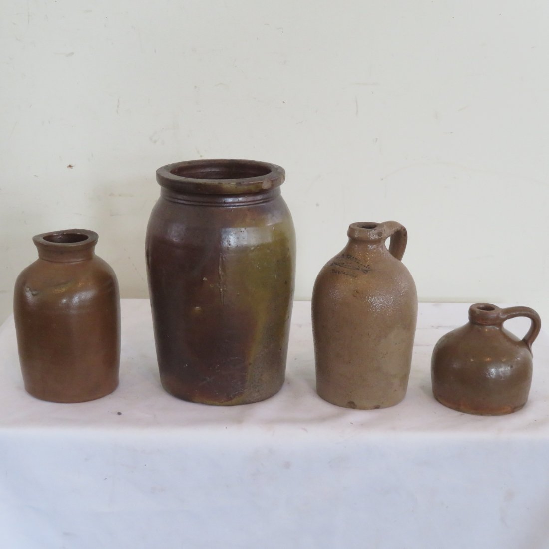 4 stoneware pcs., 2 jars and 2 jugs: 4 stoneware pcs, 2 jars & 2 jugs, 1 qt jar signed William Hare, Wilmington, Del. 7.25"H, 1 gal jar unsigned redware with glaze 10"H, 1 qt jug, T.D. Watson, Liquor Merchant 8"H, 1 pint jug unmarked 4.2