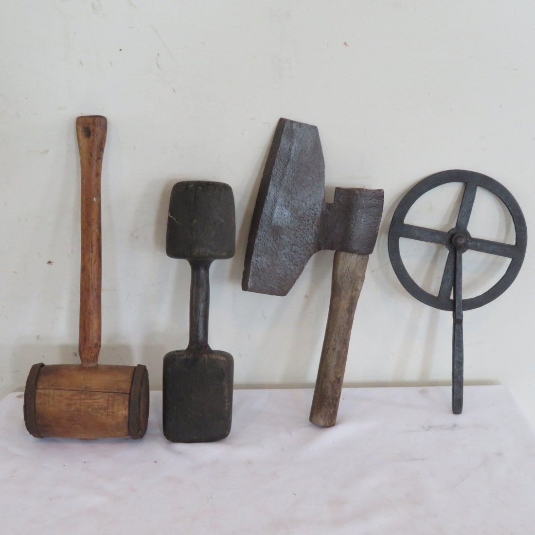 4 old tools: 2 wooden mallets, metal & wood broad axe is 17" x 7", metal wheel wright traveler