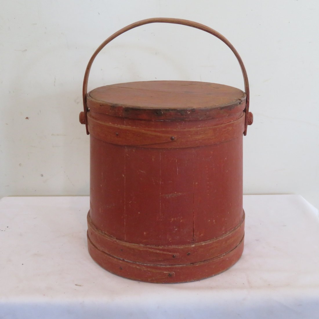 Wood firkin with wood handle in old red paint: Wood firkin with wood handle in old red paint, nailed fingers, top is 11 1/2" dia., bottom 12 1/4", 12"H
