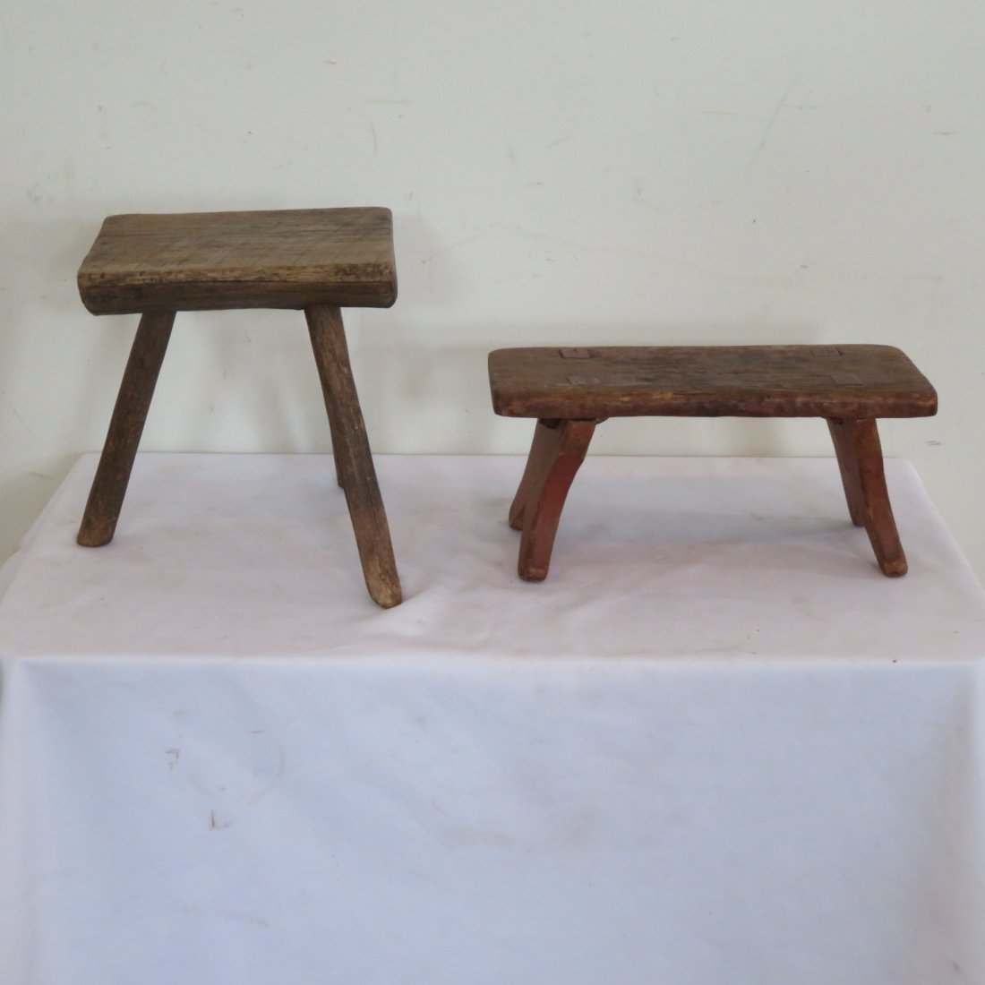 3 leg milking stool, red painted footstool: 2 wooden stools - 3 leg milking stool 11"H x 9"W, red painted footstool with feet mortised through the top 6"H x 13"W