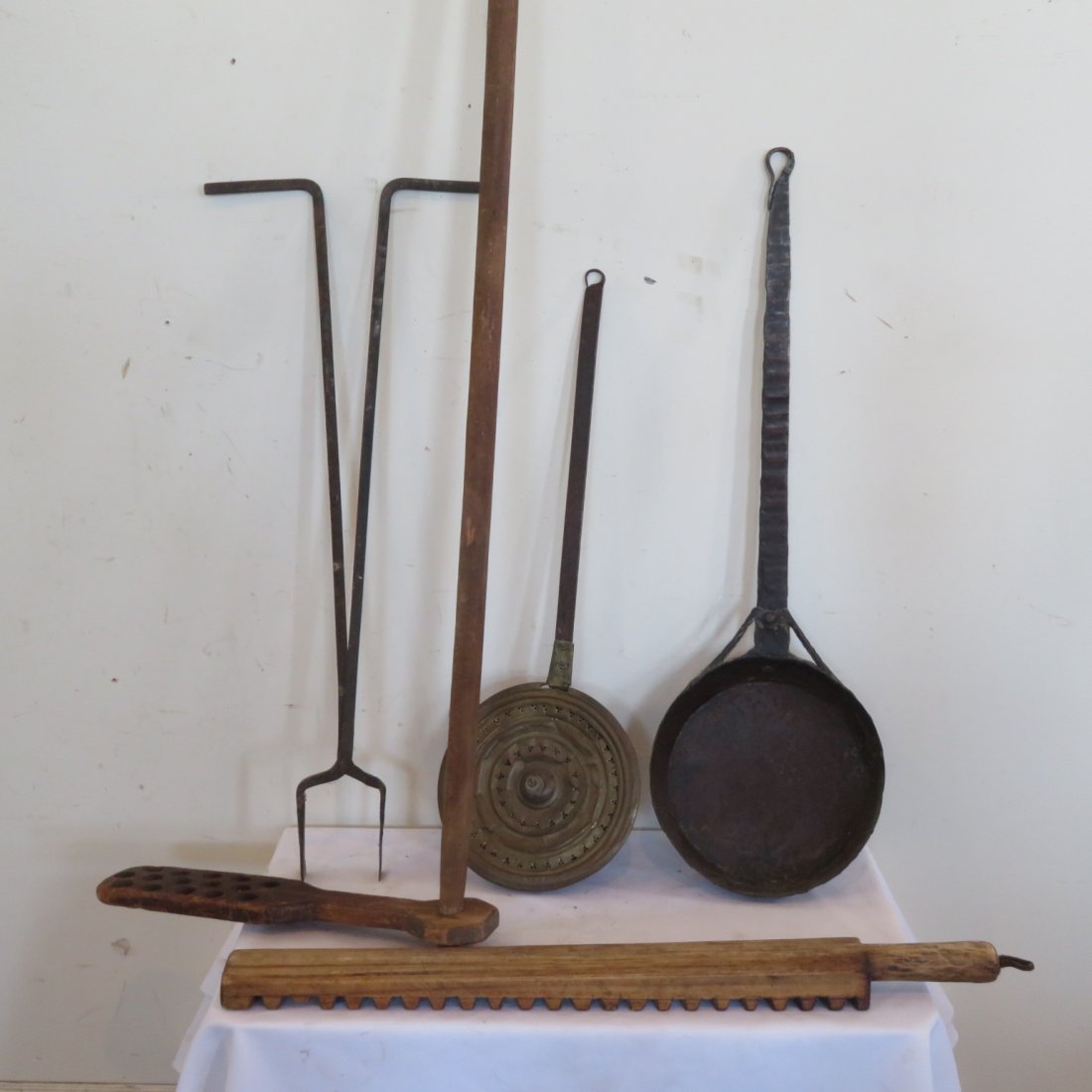 5 early assorted tools: Wood apple butter stirrer with 6' handle, iron and brass bedwarmer, iron long handle skillet, set of iron tongs and a wood mangle.