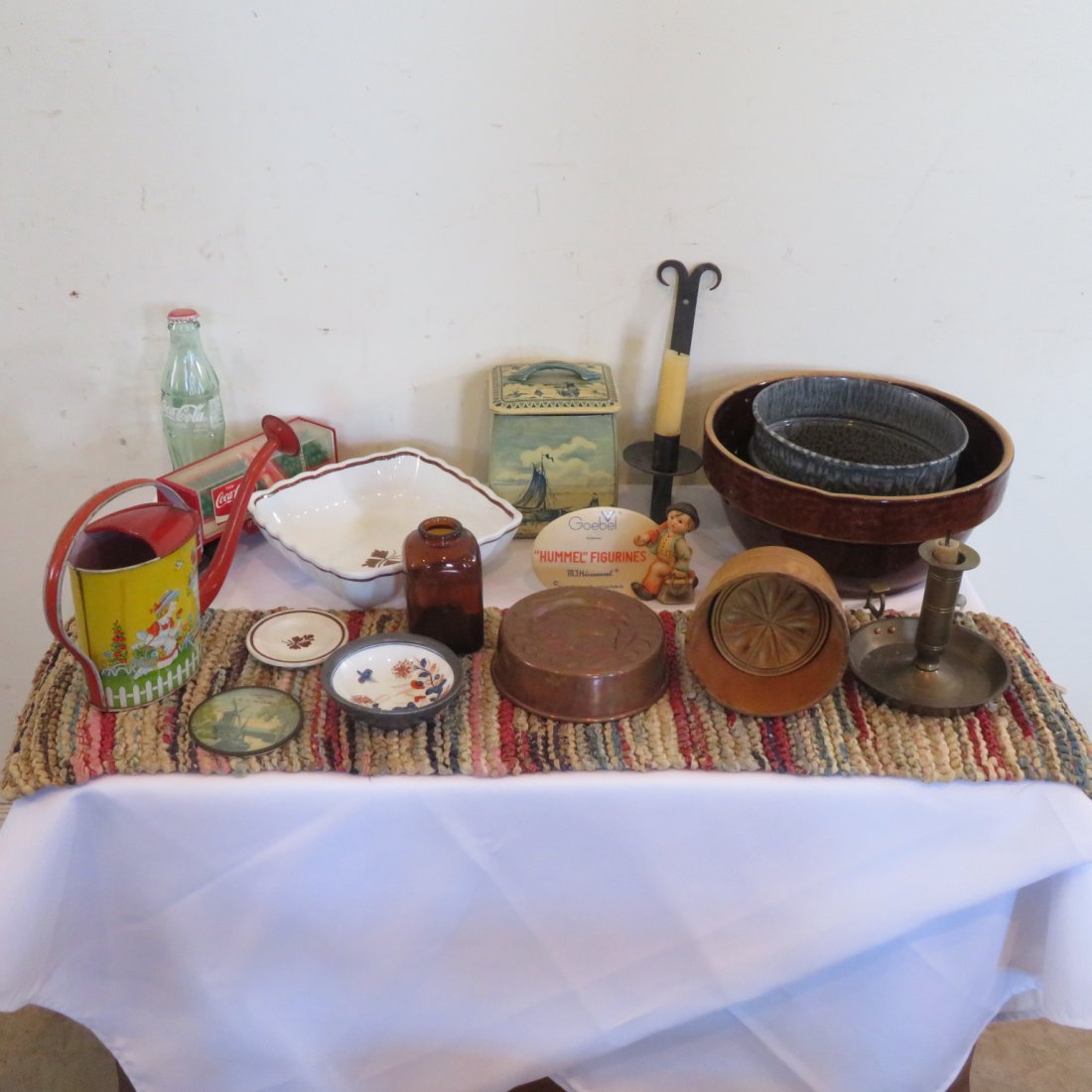 Group of 17 misc items: Group of 17 misc items, includes Chein tin litho watering can, Hummel store plague, wood butter mold, Tea Leaf Ironstone square vegetable bowl, pewter porcelain lined oriental bowl, rag table runner, 