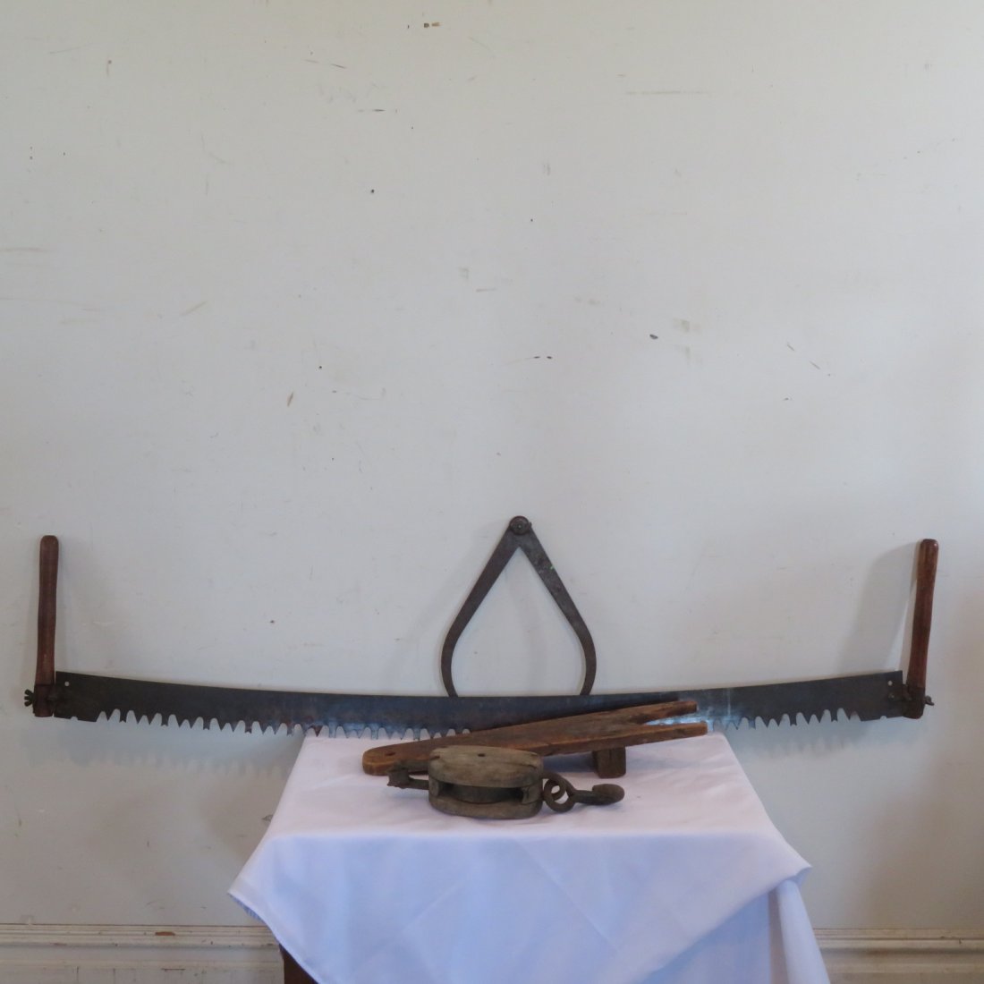 Group of 4 tools: Group of 4 tools: Iron caliper, crosscut saw is 64"L, boot jack, wood and iron pulley