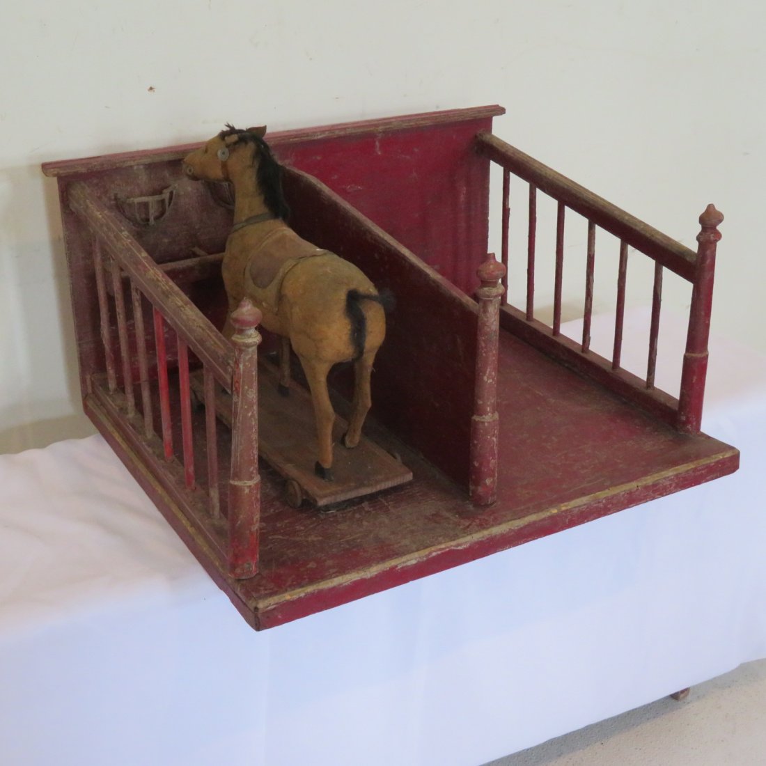 Child's stable with horse on wheels: Child's stable with felt covered horse on wheels, stable is in old red paint and has feed and hay bunks, stable is 11"H x 22"W x 17"D, horse is 11.25"H x 12"L x 4"W