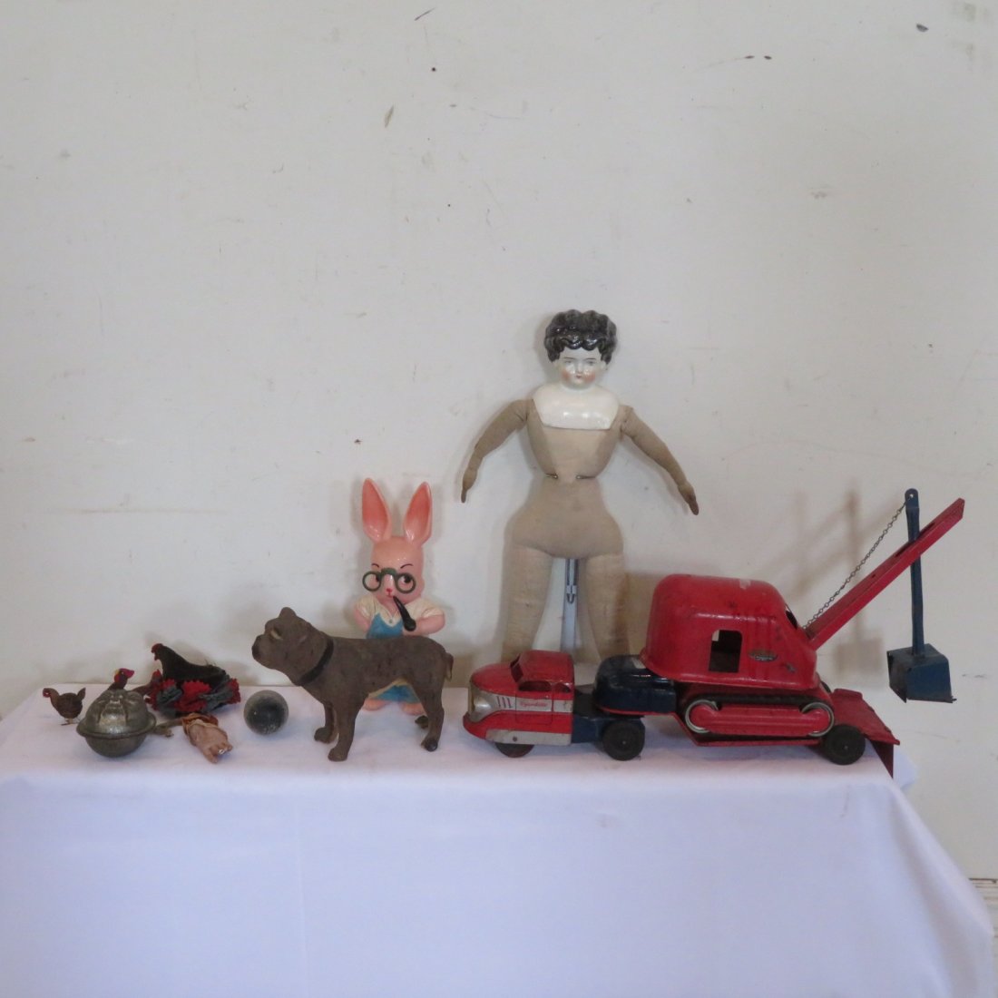 Group of toys etc.: Wyandotte toy 20\" pressed steel truck and flat bed trailer with a Tonka pressed steel steam shovel missing one rubber track, a 20\" china head doll, a dog on wheels (2 wheels missing), a plastic rabb