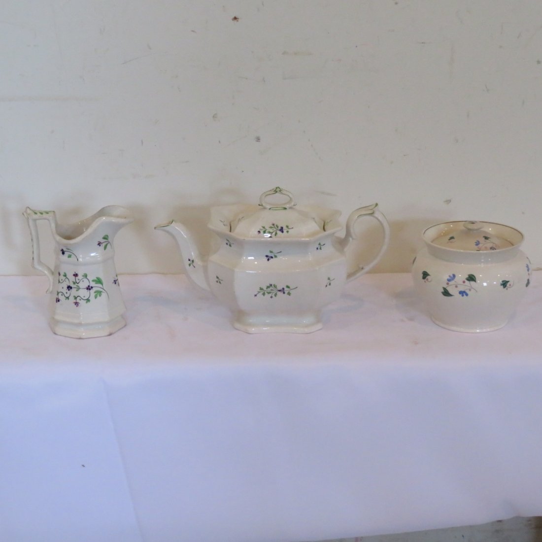 3 pieces of early china: 3 pieces of early china includes Staffordshire teapot, creamer and a handless covered sugar bowl, all have different patterns and no markings, teapot is 7" t. x 11" l.
