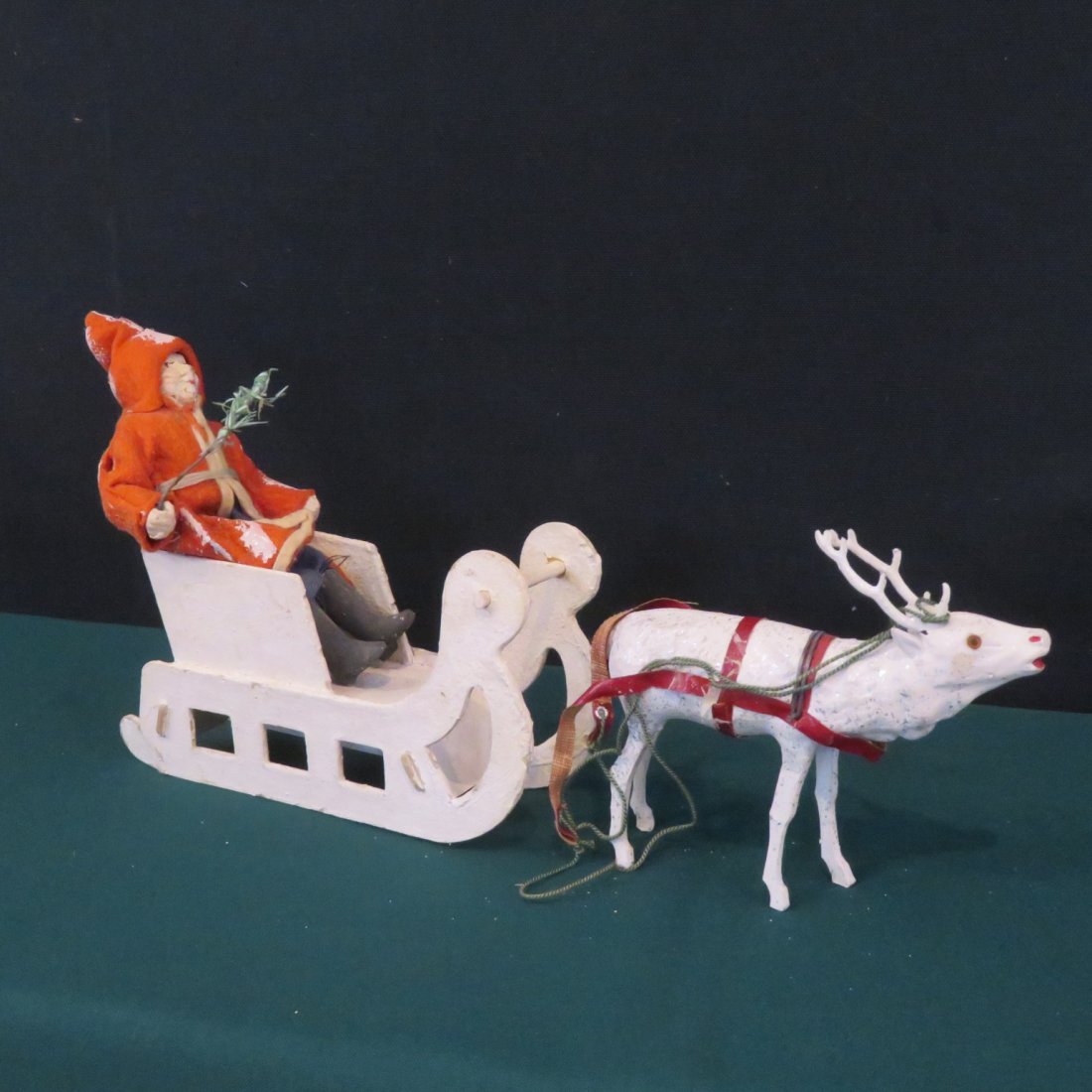 Felt suit Santa with cardboard sleigh and reindeer: Felt suit Santa with cardboard sleigh and reindeer, Santa's holding a feather tree and has a paper mache face, reindeer has glass eyes, sled has a mark on bottom that is hard to read, 12"L