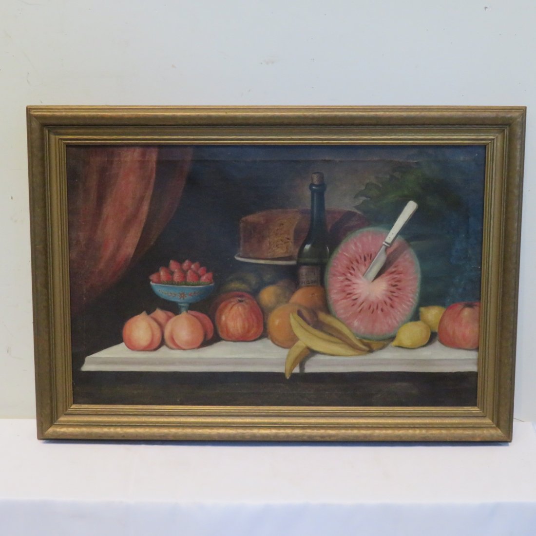 Late 19th century O/C still life painting: Late 19th century O/C still life painting with fruit, cake on pedestal, wine bottle all on table top with a red drape in background, sight 27" x 17", 2 1/2" frame, wonderful colors