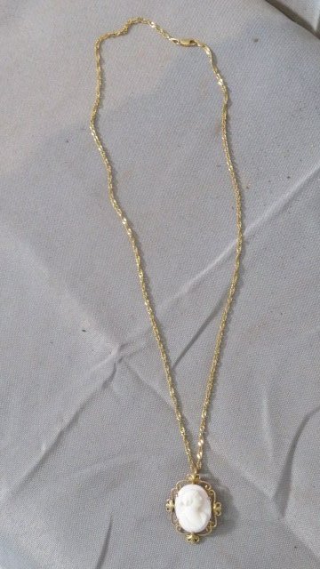 Cameo necklace with a marked 14k gold chain: Cameo necklace with a marked 14k gold chain, 20" chain is also marked Italy, cameo has markings that we can't make out, .13 standard ounces
