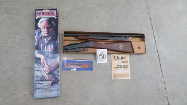 Daisy Ca. 1985 Centennial Model 25 BB gun NIB: Daisy Ca. 1985 Centennial Model 25 pump BB rifle, new in original box, never fired, still has hang tag & instructions, walnut wood stock and grip, Centennial Medallion on stock, box is 25" x 6 1/2"
