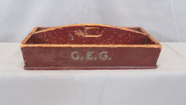 Nailed wood utensil carrier in old red paint: Nailed wood utensil carrier in old red paint, initials C.E.G. in gray paint with yellow highlights on side, mix of square and round nails, 4.5"T x 15.5"L x 8"W