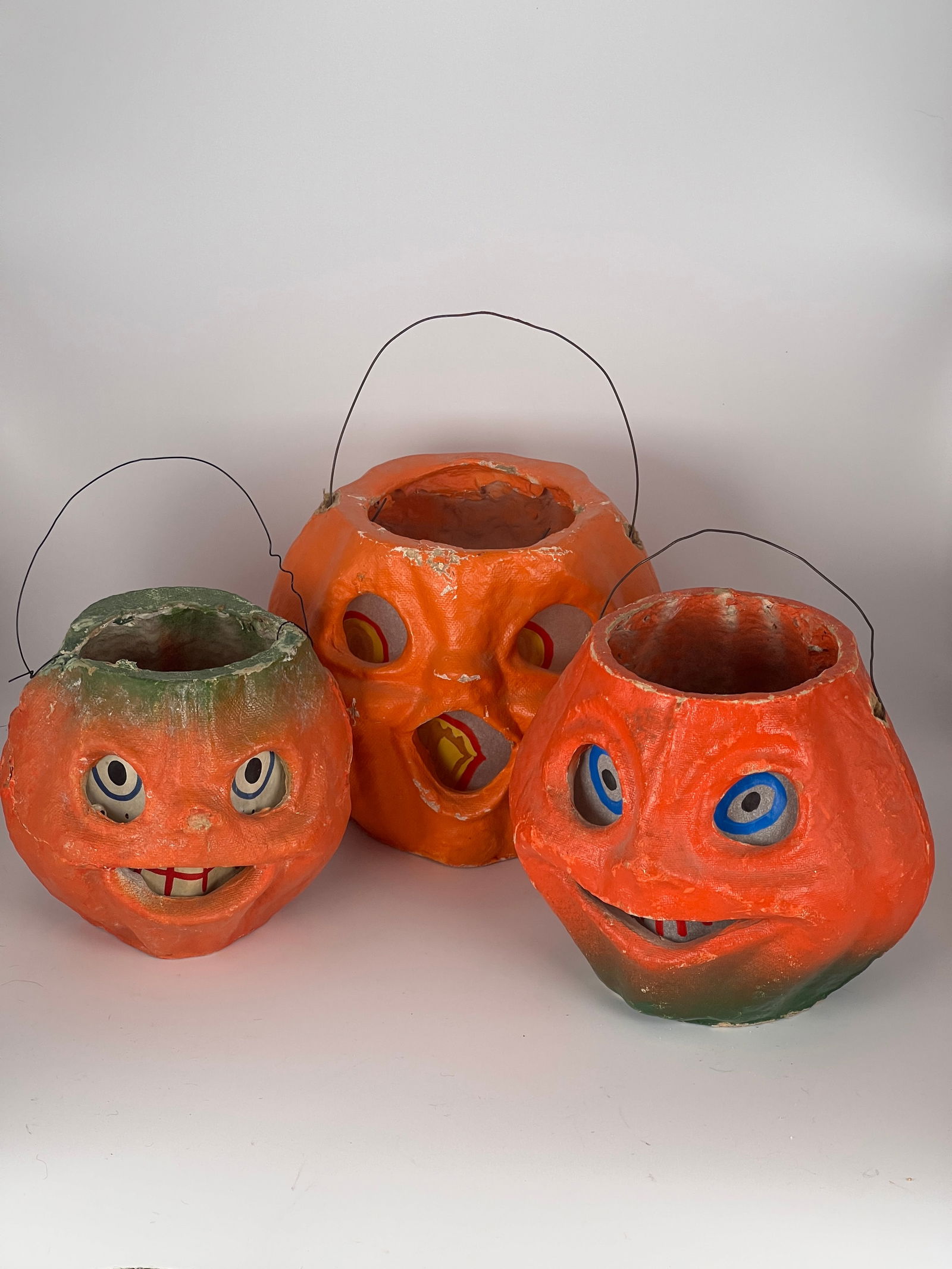 Three Paper Mache Jack O'Lanterns: Three paper mache Jack O'Lanterns, all w/wire bail handles, all replaced paper face inserts, all with condition issues. All approx. 5"W x 5"T