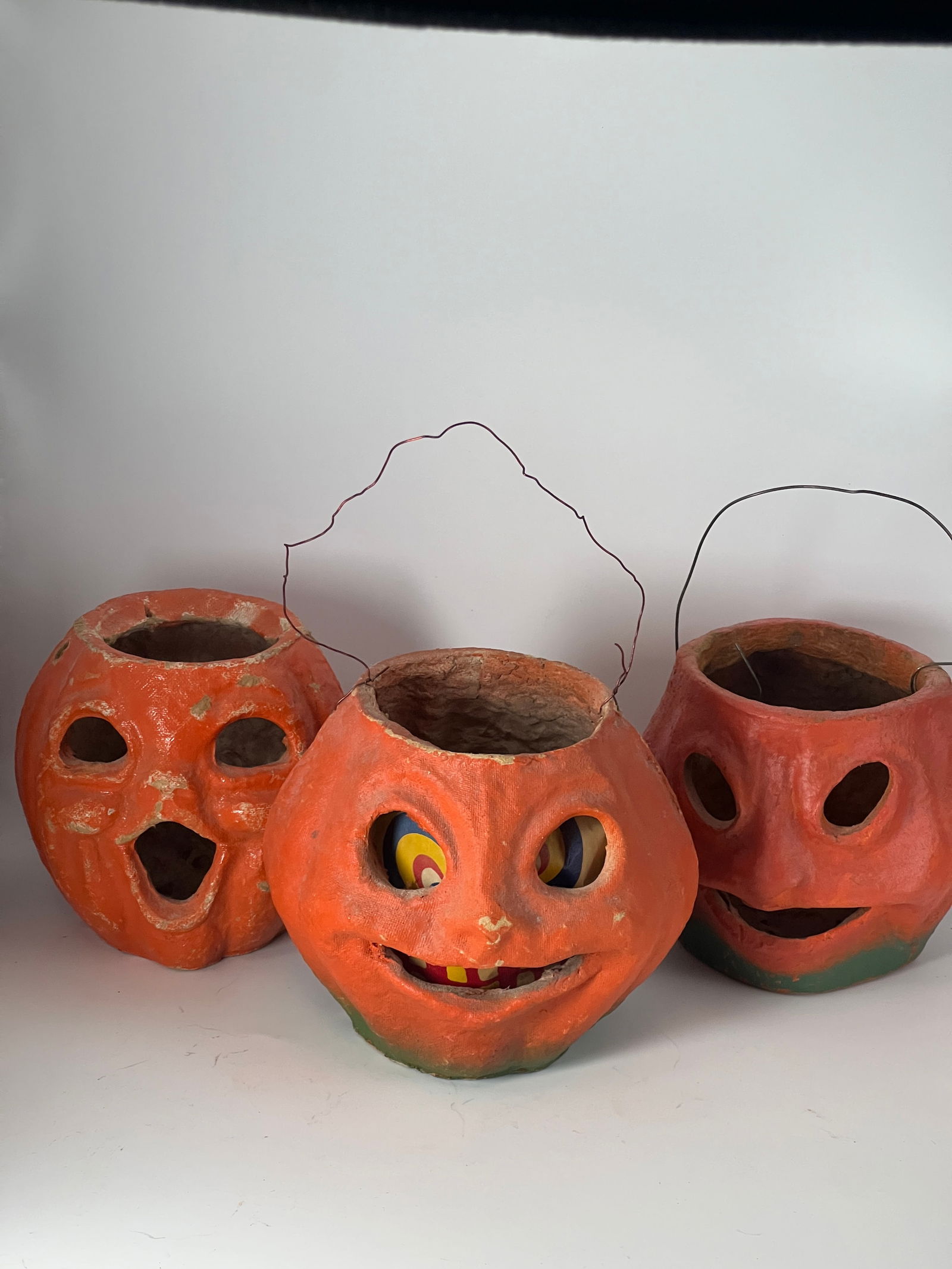 Three Paper Mache Jack O'Lanterns: Three Paper Mache Jack O'Lanterns: orange w/green accent & original paper face insert, orange w/green accent & no paper face - very good condition, & orange w/missing bail & paint loss. 5"W x 4"T